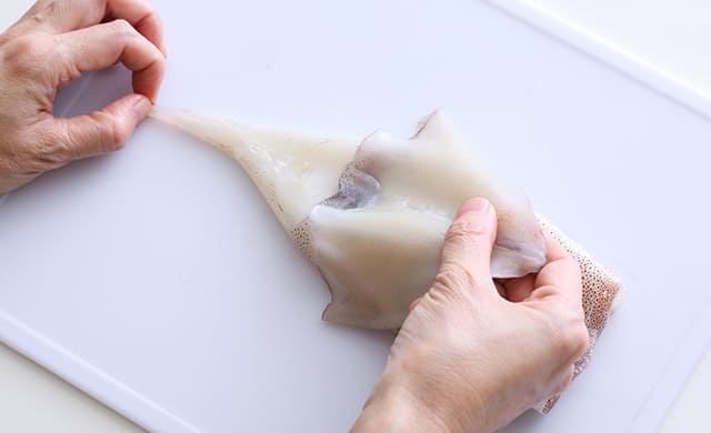 イカの皮をむいている写真