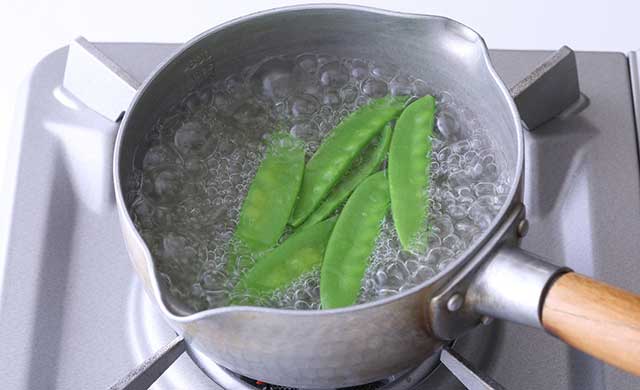 鍋で絹さやをゆでている写真