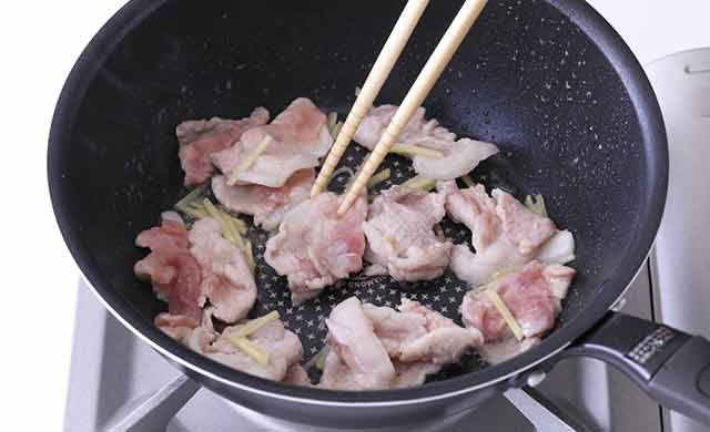 フライパンで肉を炒めている写真