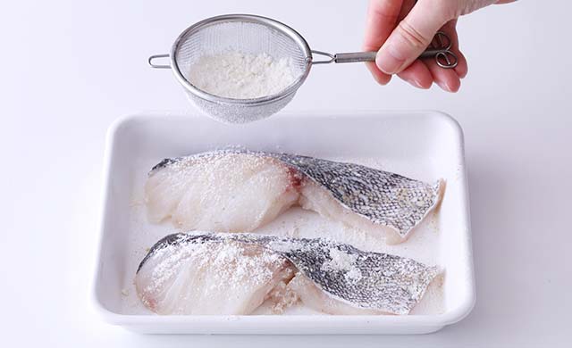 茶漉しでたらに小麦粉をふっている写真