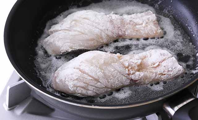 フライパンでたらの皮目を焼いている写真