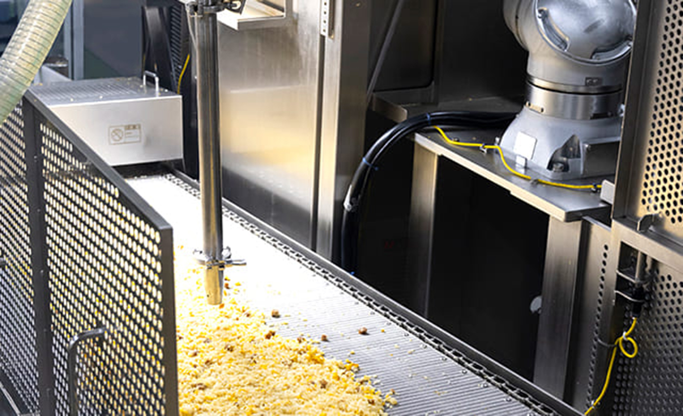 工場の炒飯製造ライン。AIとロボットを連動させ、炒飯のこげをピンポイントで吸い取る技術を導入